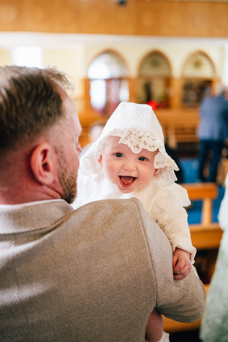 Baby boy during christening ceremony at Carraroe Church, Sligo with parents