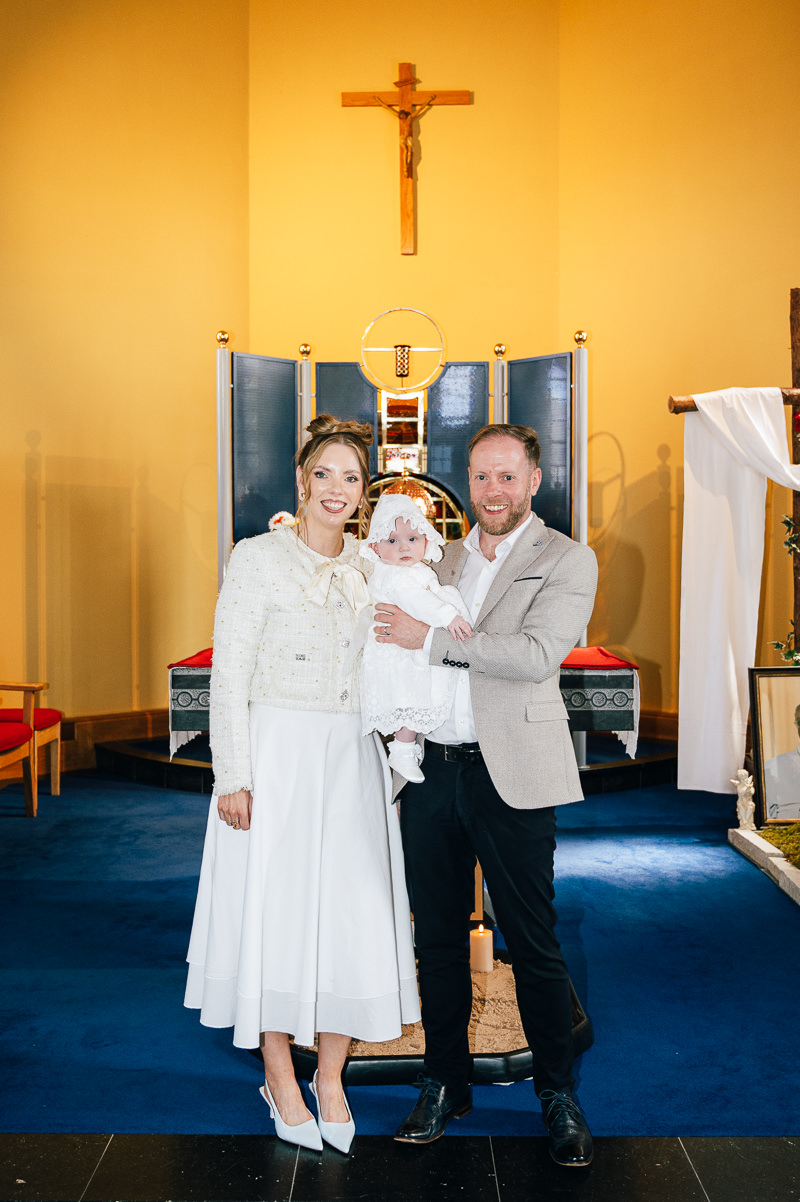 Baby boy during christening ceremony at Carraroe Church, Sligo with parents by the altar